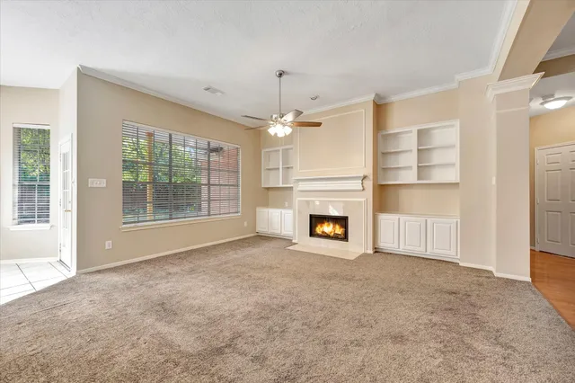 a view of an empty room with a fireplace and a window