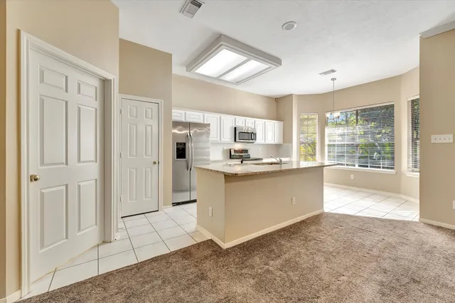 a large white kitchen with cabinets and a refrigerator