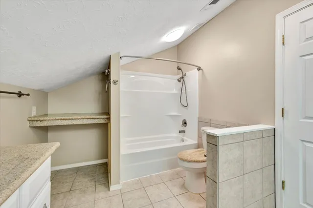 an empty room with ceiling fan and windows