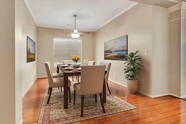 a dining room with furniture potted plants and wooden floor