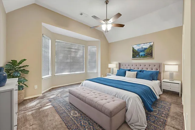 a spacious bedroom with a large bed and a chandelier