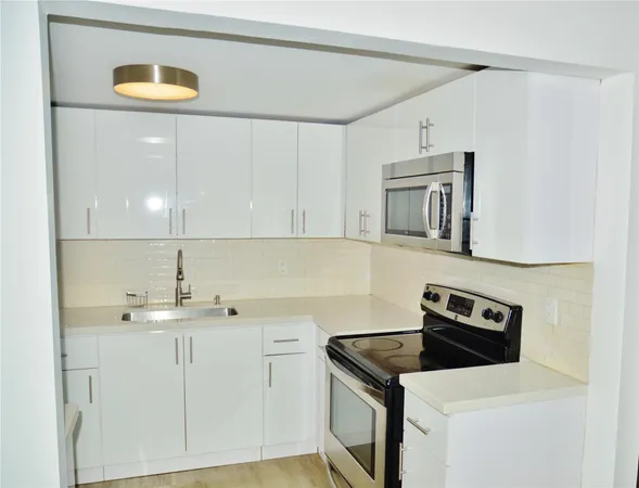 a kitchen with a sink cabinets and appliances