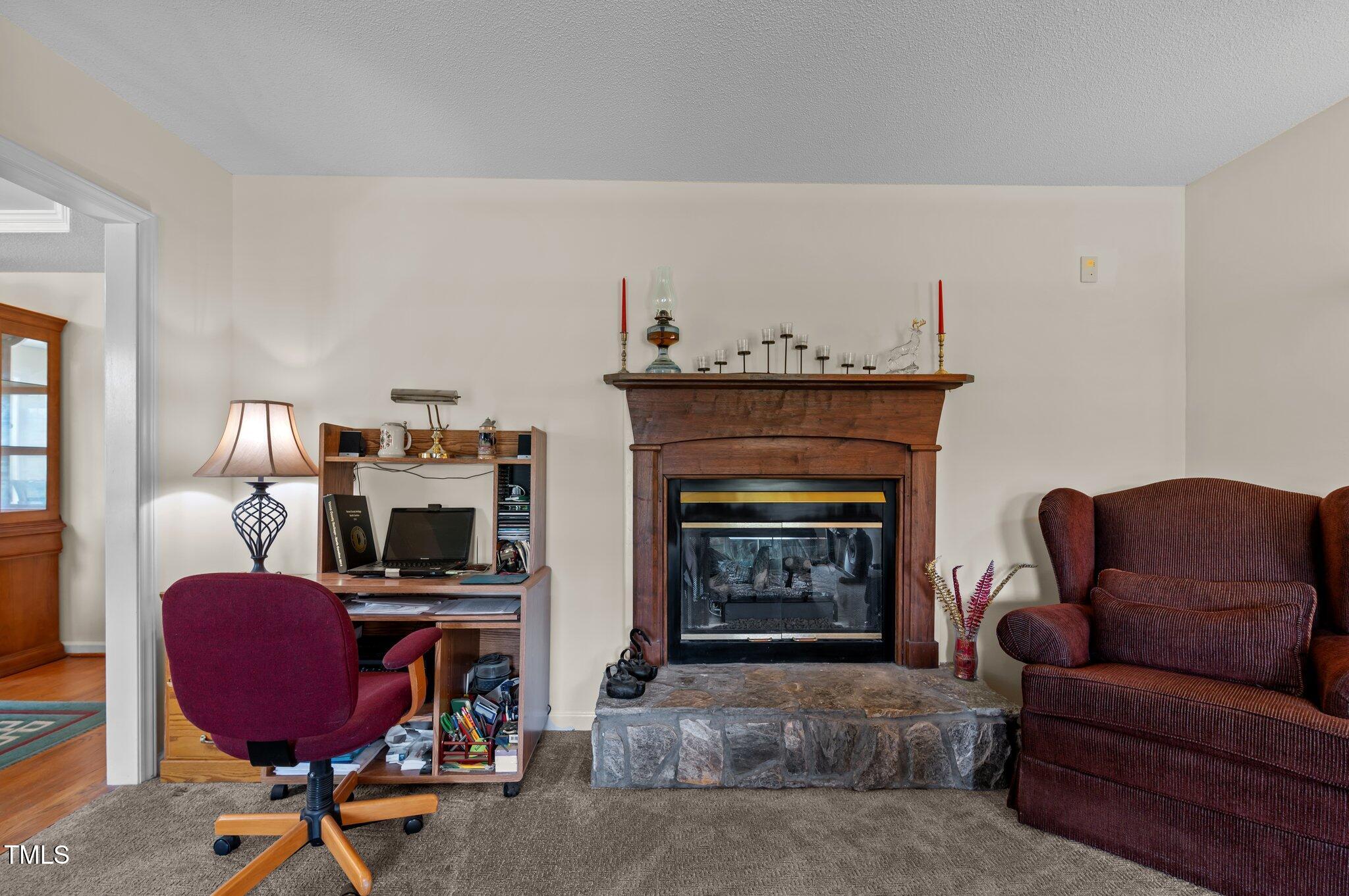 675 Anderson Creek Road Henderson, NC 27537 - Photo 35 of 62 a living room with furniture a fireplace and a flat screen tv