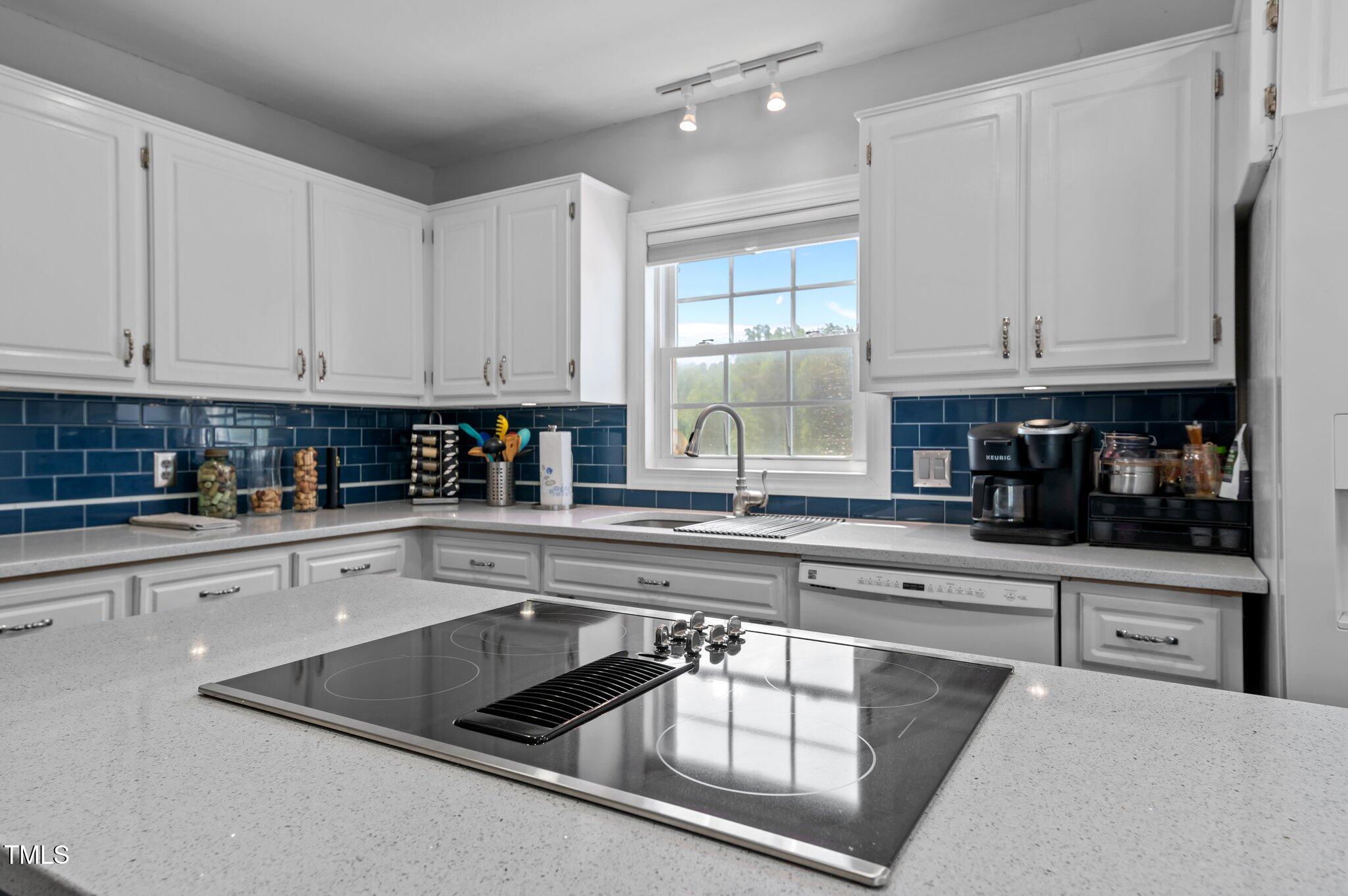 675 Anderson Creek Road Henderson, NC 27537 - Photo 41 of 62 a kitchen with granite countertop white cabinets and white appliances
