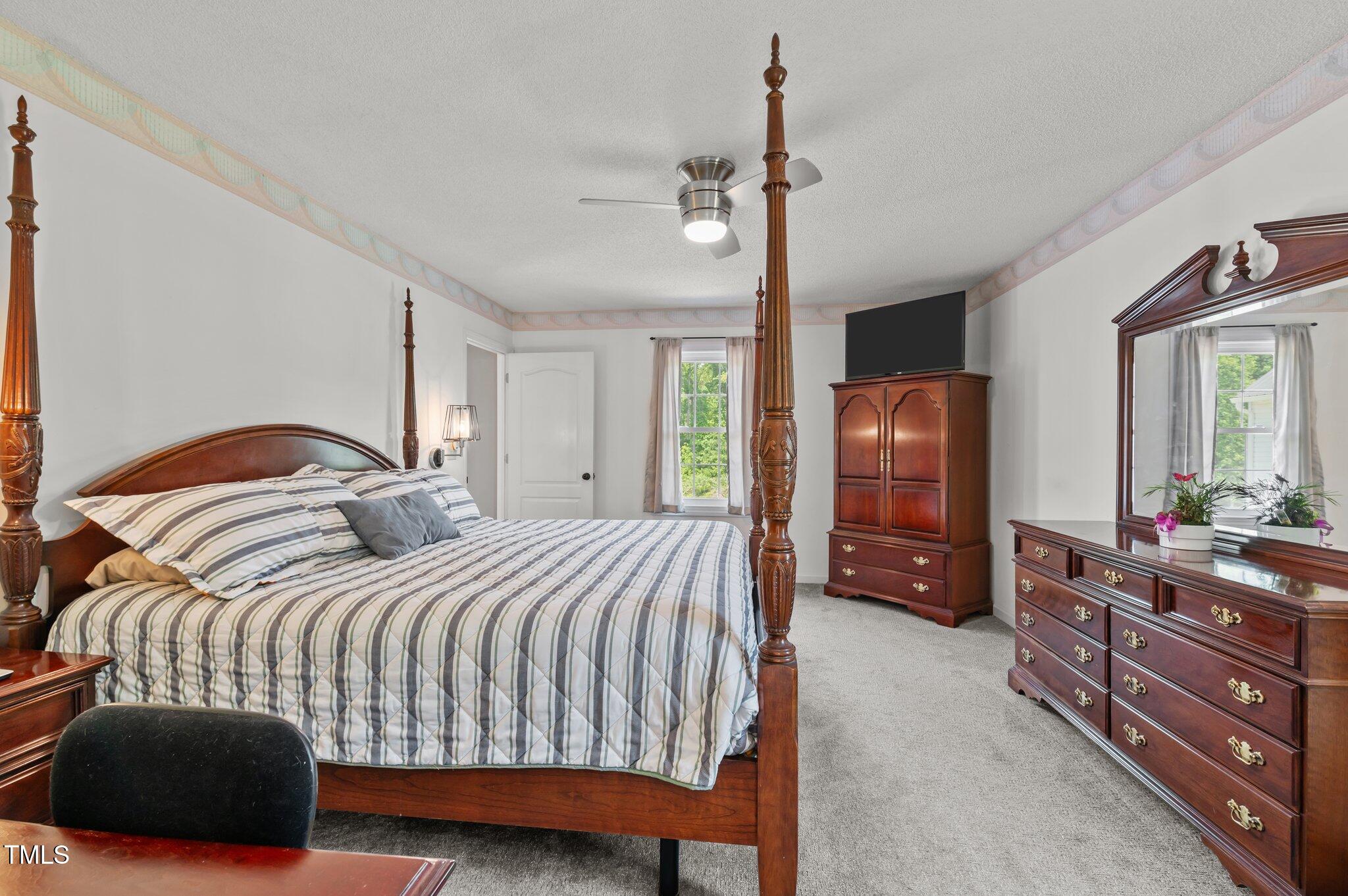 675 Anderson Creek Road Henderson, NC 27537 - Photo 48 of 62 a bedroom with a bed a dresser and flat screen tv
