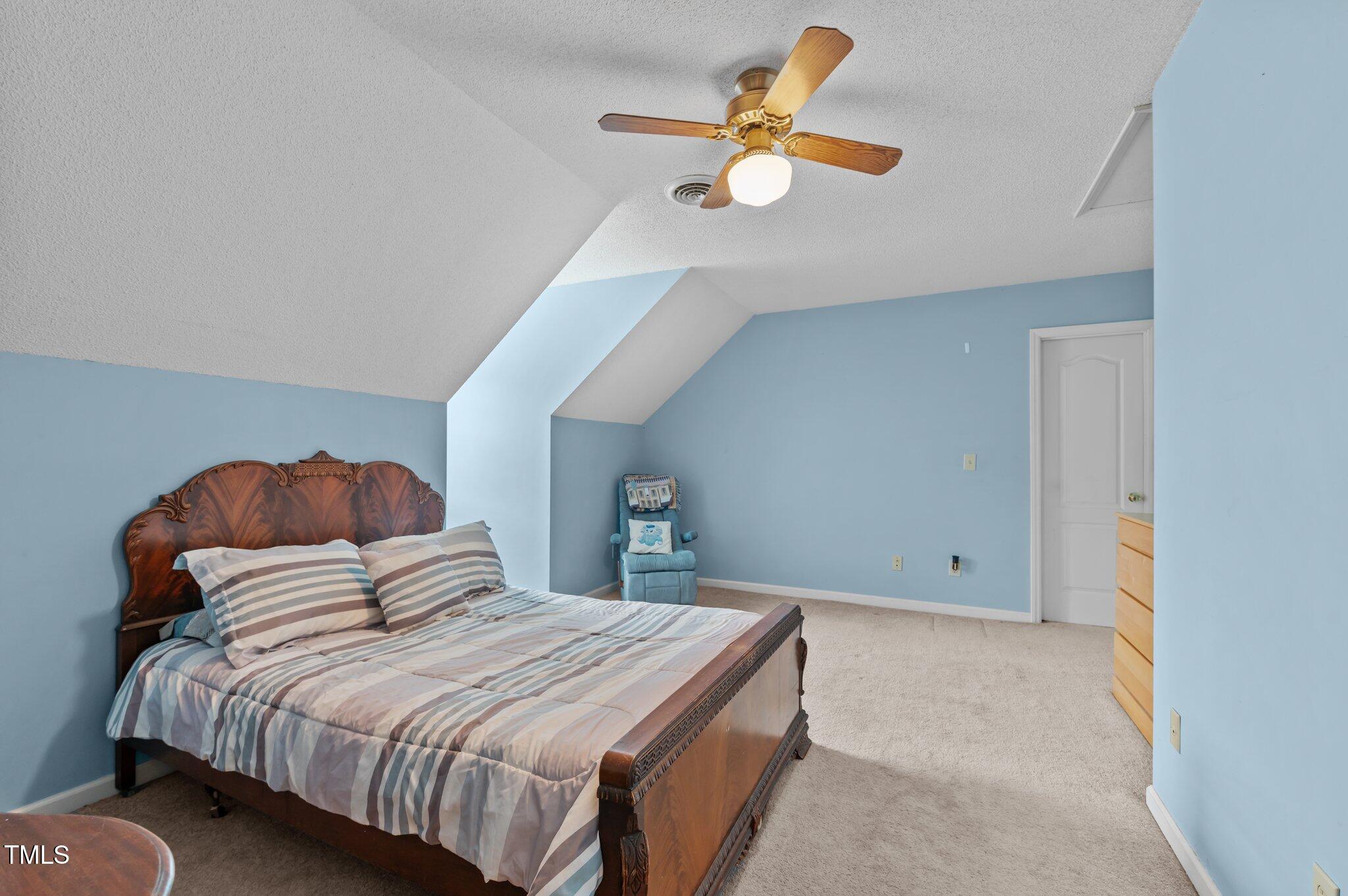 675 Anderson Creek Road Henderson, NC 27537 - Photo 55 of 62 a bedroom with a bed and a chandelier