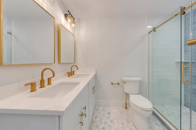 a bathroom with a sink a toilet and shower