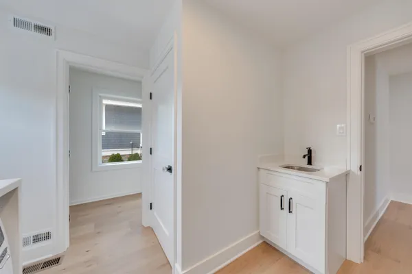 a kitchen that has a lot of white cabinets and stainless steel appliances
