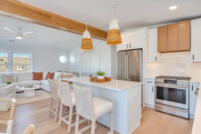 a kitchen with stainless steel appliances a stove a refrigerator and a dining table