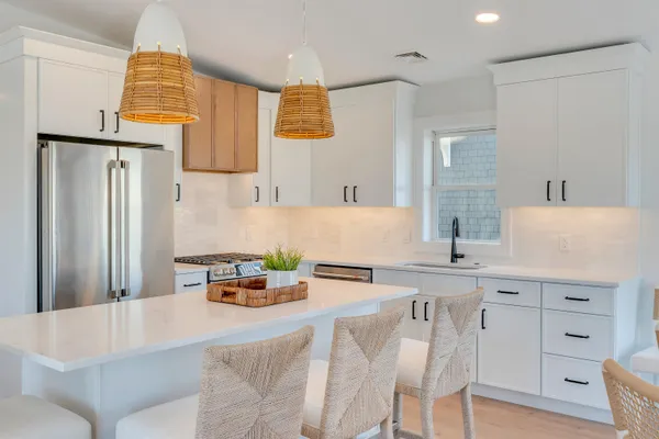 a kitchen with stainless steel appliances a stove a refrigerator and a dining table