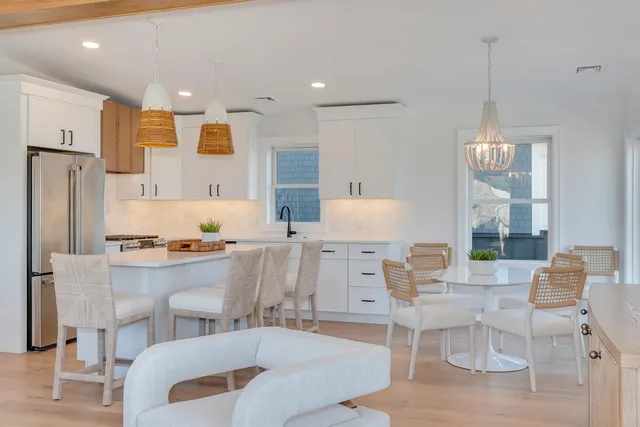 a living room with stainless steel appliances furniture a dining table and chairs