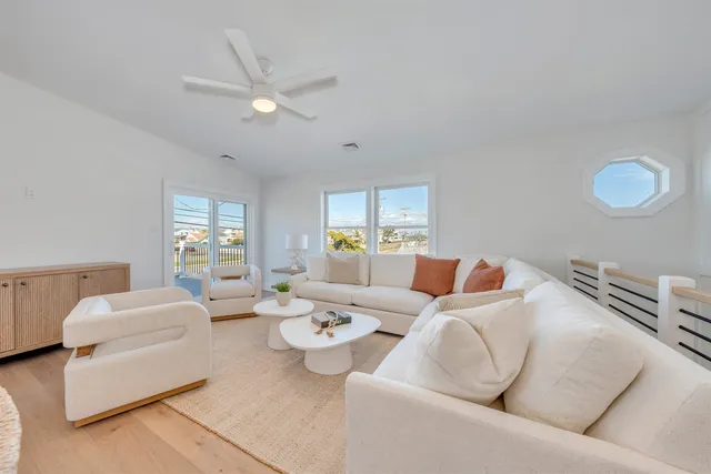 a living room with stainless steel appliances furniture a dining table and chairs