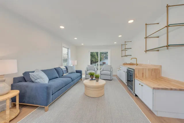 a living room with furniture and a dining table with wooden floor