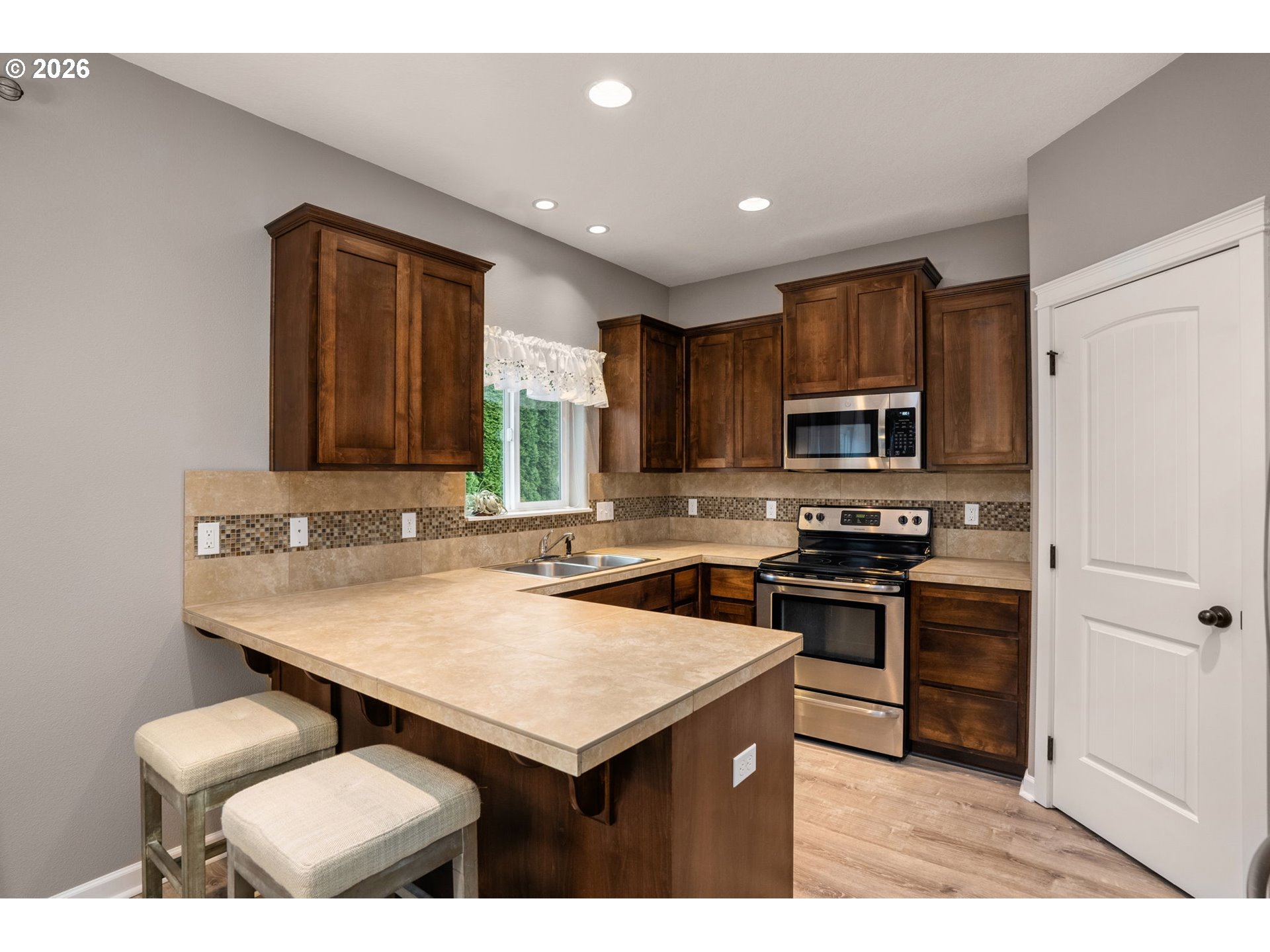 52183 Southeast Tussing Way Scappoose, OR 97056 - Photo 11 of 32 a kitchen with stainless steel appliances a sink a stove a refrigerator cabinets and a dining table