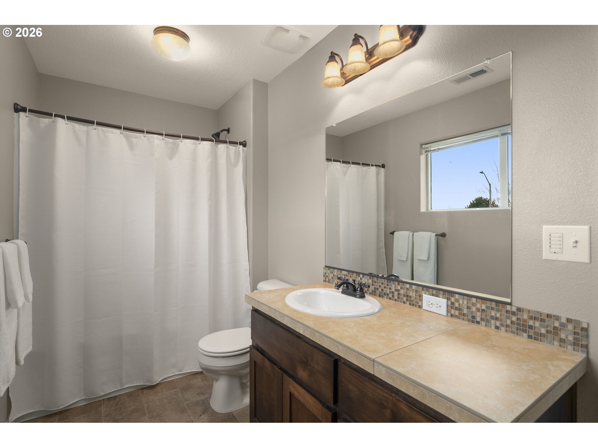 52183 Southeast Tussing Way Scappoose, OR 97056 - Photo 21 of 32 a bathroom with a granite countertop sink a toilet and a mirror