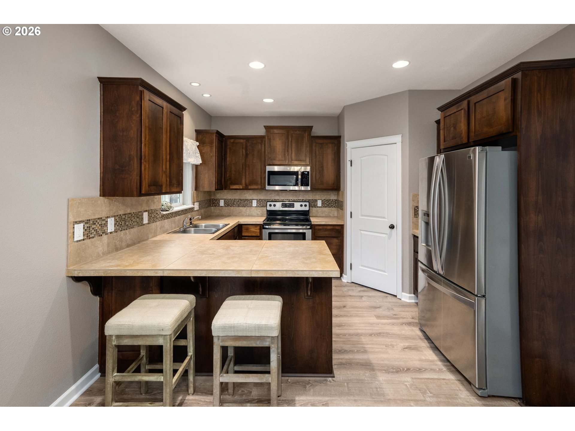 52183 Southeast Tussing Way Scappoose, OR 97056 - Photo 10 of 32 a kitchen with stainless steel appliances kitchen island granite countertop a refrigerator a stove a sink dishwasher with a dining table and chair