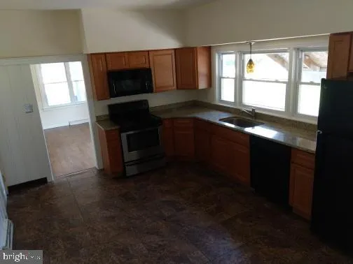 a kitchen with granite countertop a stove a sink and a microwave