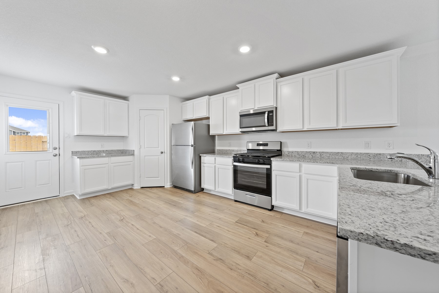 369 Silent Meadow Run Maxwell, TX 78656 - Photo 2 of 8 a kitchen with white cabinets and stainless steel appliances