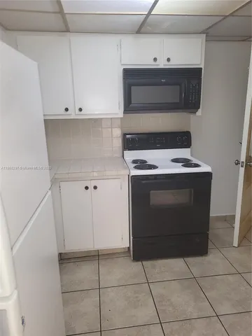 a stove top oven sitting inside of a kitchen