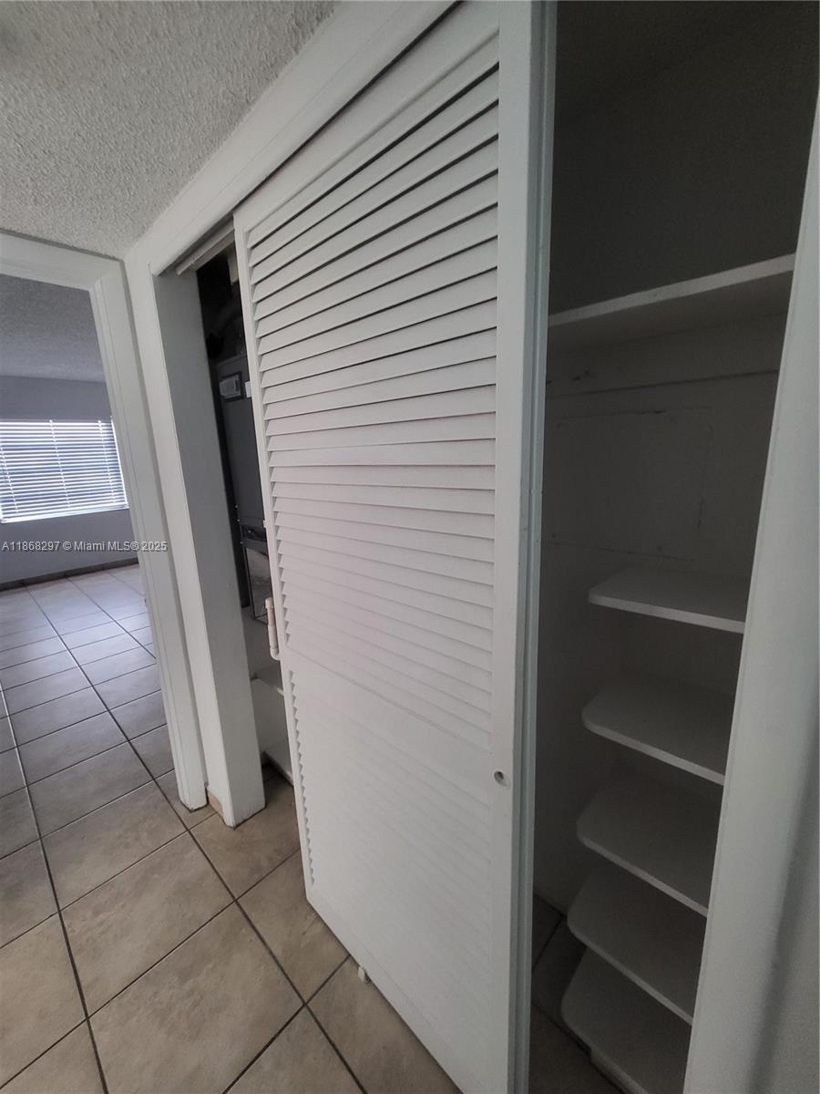 1175 Normandy Drive, Unit 2D Miami Beach, FL 33141 - Photo 7 of 13 a view of walk in closet with empty racks