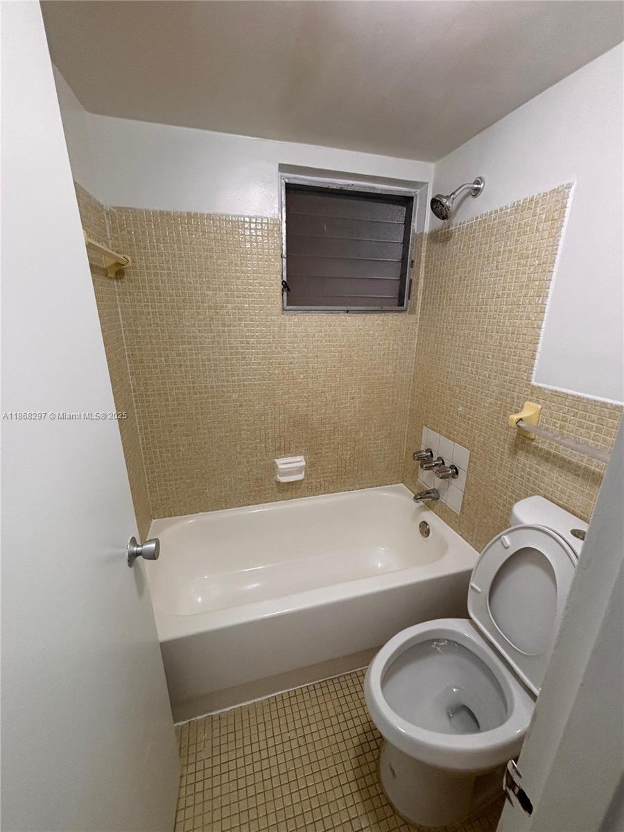 1175 Normandy Drive, Unit 2D Miami Beach, FL 33141 - Photo 10 of 13 a bathroom with a sink a toilet and bathtub