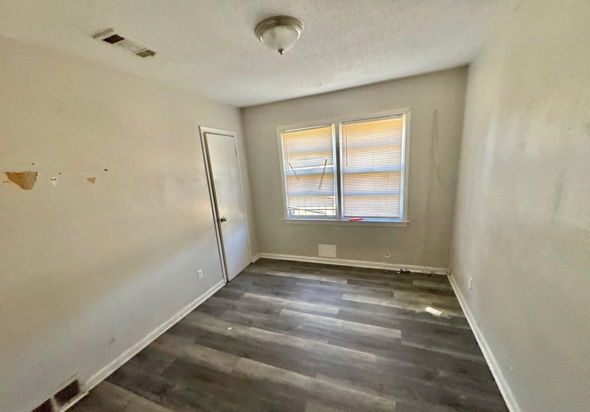 4826 Leonard Road Memphis, TN 38109 - Photo 7 of 8 Unfurnished room with dark wood finished floors and a textured ceiling
