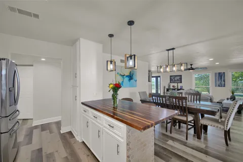a kitchen with stainless steel appliances granite countertop a table and chairs in it