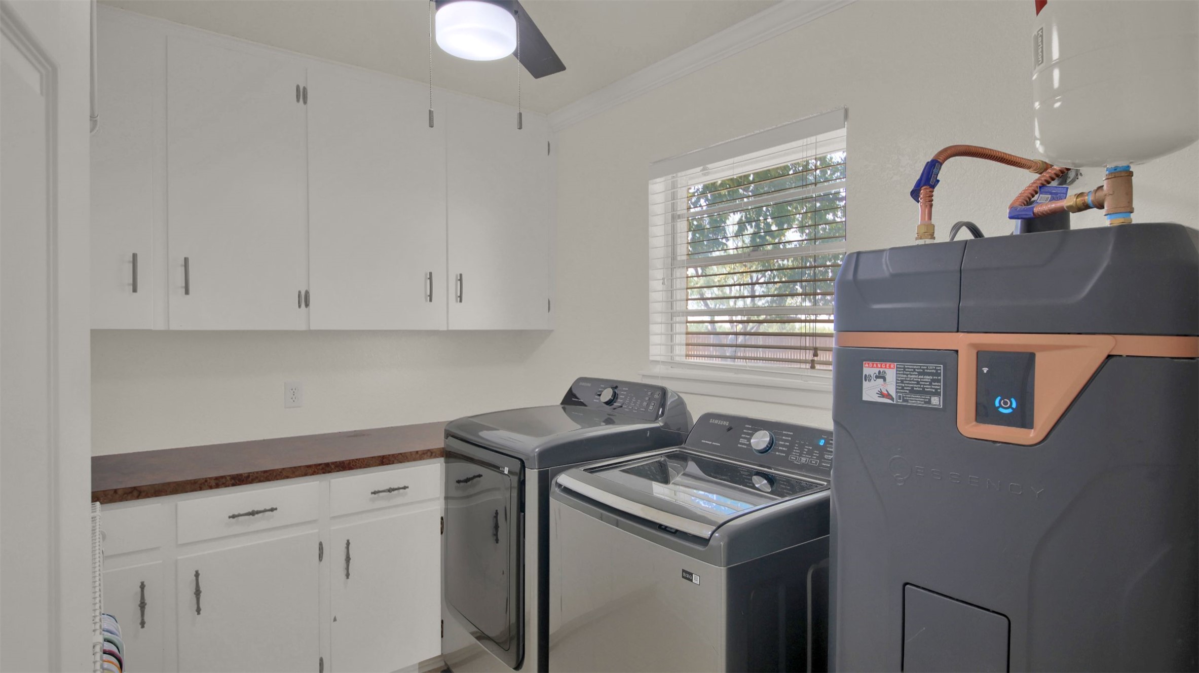 550 C.Bud Stockton Loop Jarrell, TX 76537 - Photo 16 of 37 Washroom featuring water heater, washing machine and clothes dryer, ornamental molding, cabinet space, and ceiling fan