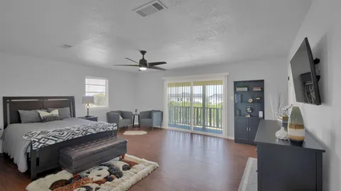 a bedroom with a large bed and a flat tv screen