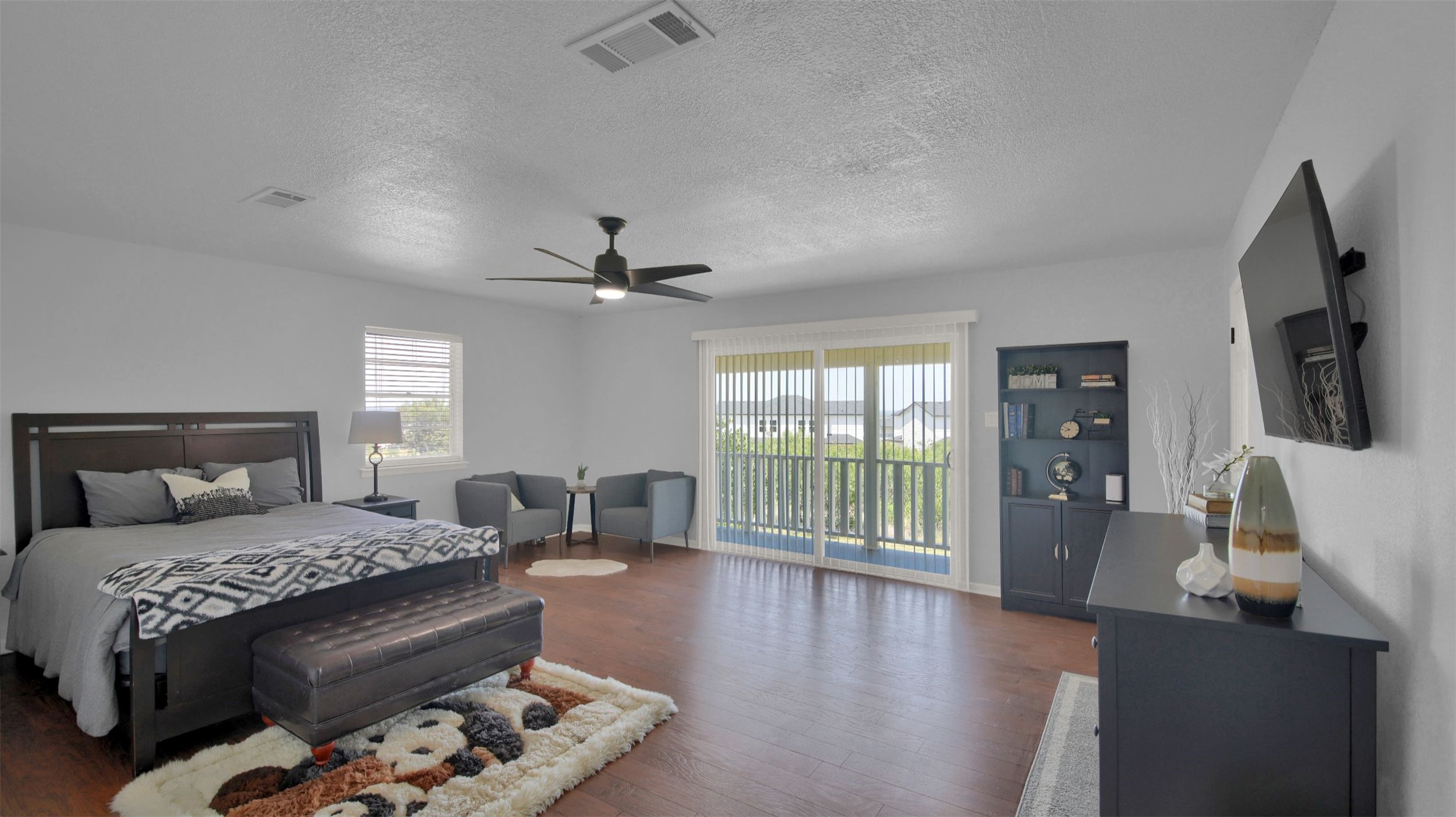 550 C.Bud Stockton Loop Jarrell, TX 76537 - Photo 27 of 37 Large secondary bedroom (upstairs) with access to outside, wood finished floors, a textured ceiling, and a ceiling fan