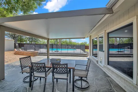a view of an outdoor dining space with a table and chairs