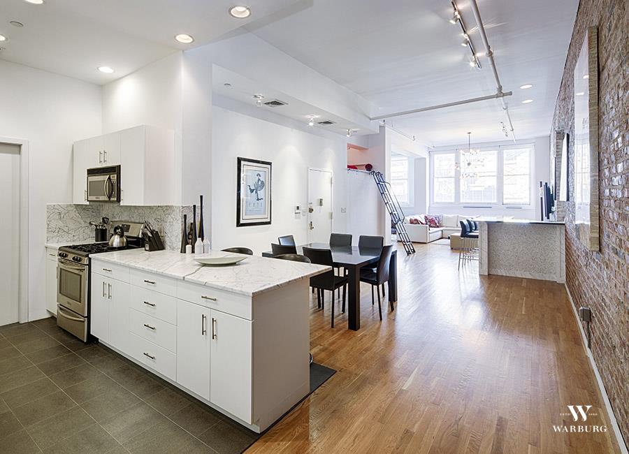 a kitchen with a sink stove and wooden floor