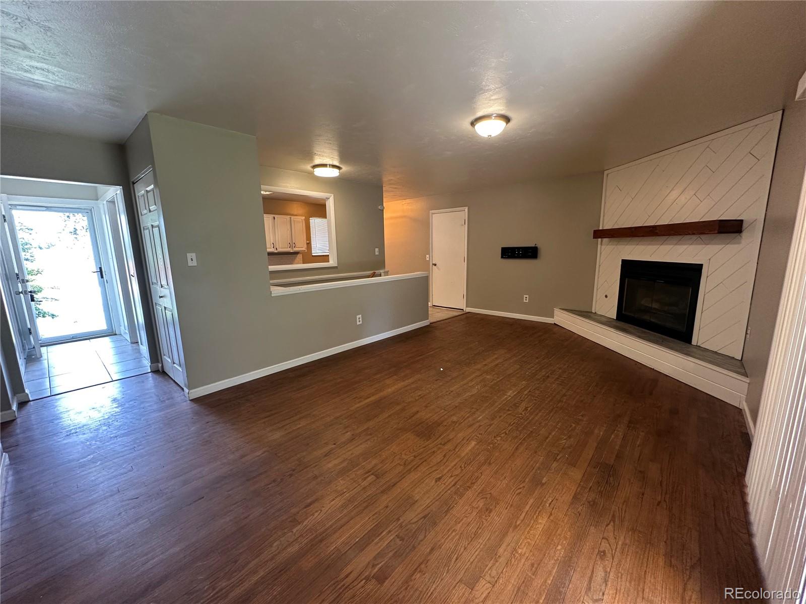 1836 East Mineral Avenue Centennial, CO 80122 - Photo 6 of 25 an empty room with wooden floor and fireplace