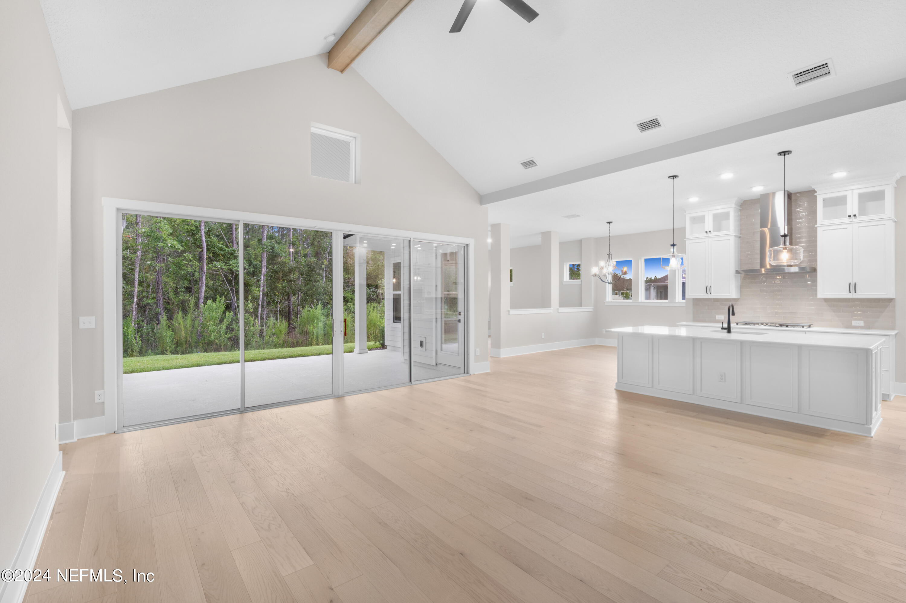 393 Canopy Forest Dr Street St. Augustine, FL 32092 - Photo 11 of 18 a large white kitchen with kitchen island a large window a sink and cabinets