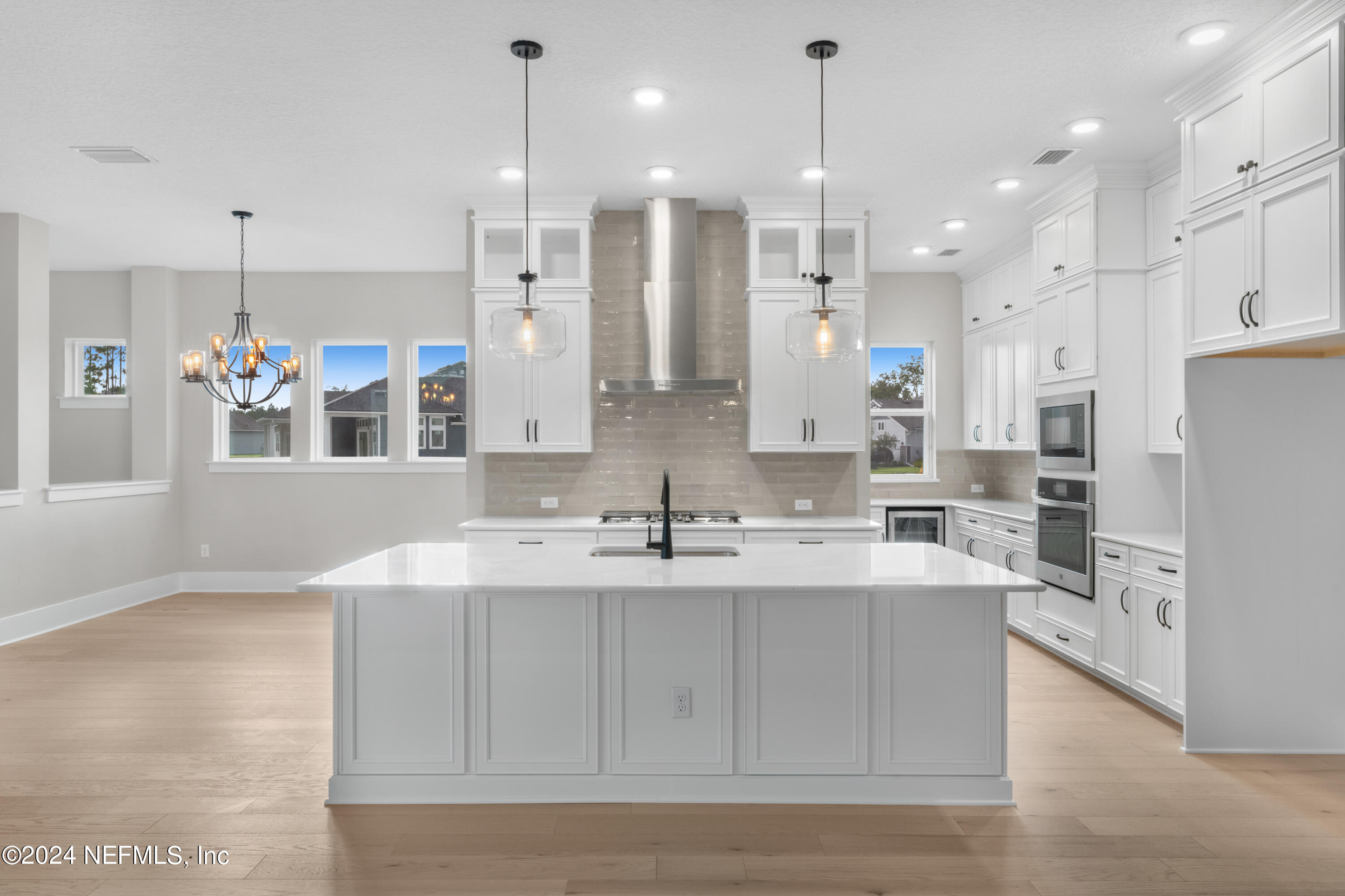 393 Canopy Forest Dr Street St. Augustine, FL 32092 - Photo 5 of 18 a large white kitchen with a large kitchen island sink and refrigerator