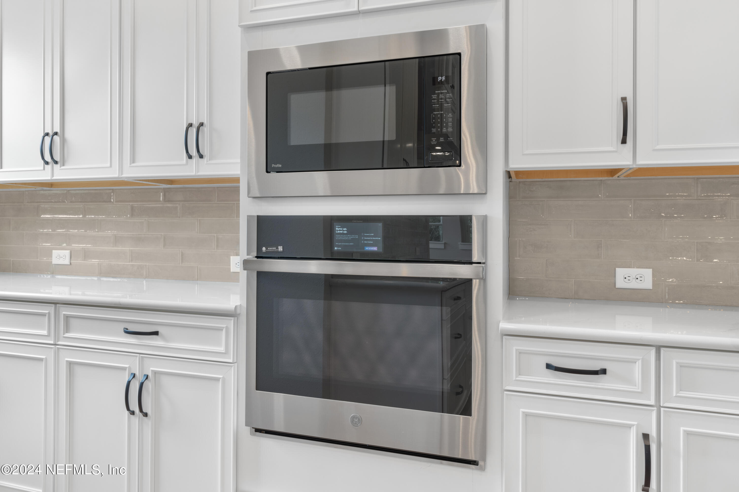 393 Canopy Forest Dr Street St. Augustine, FL 32092 - Photo 8 of 18 a kitchen with white cabinets and white appliances