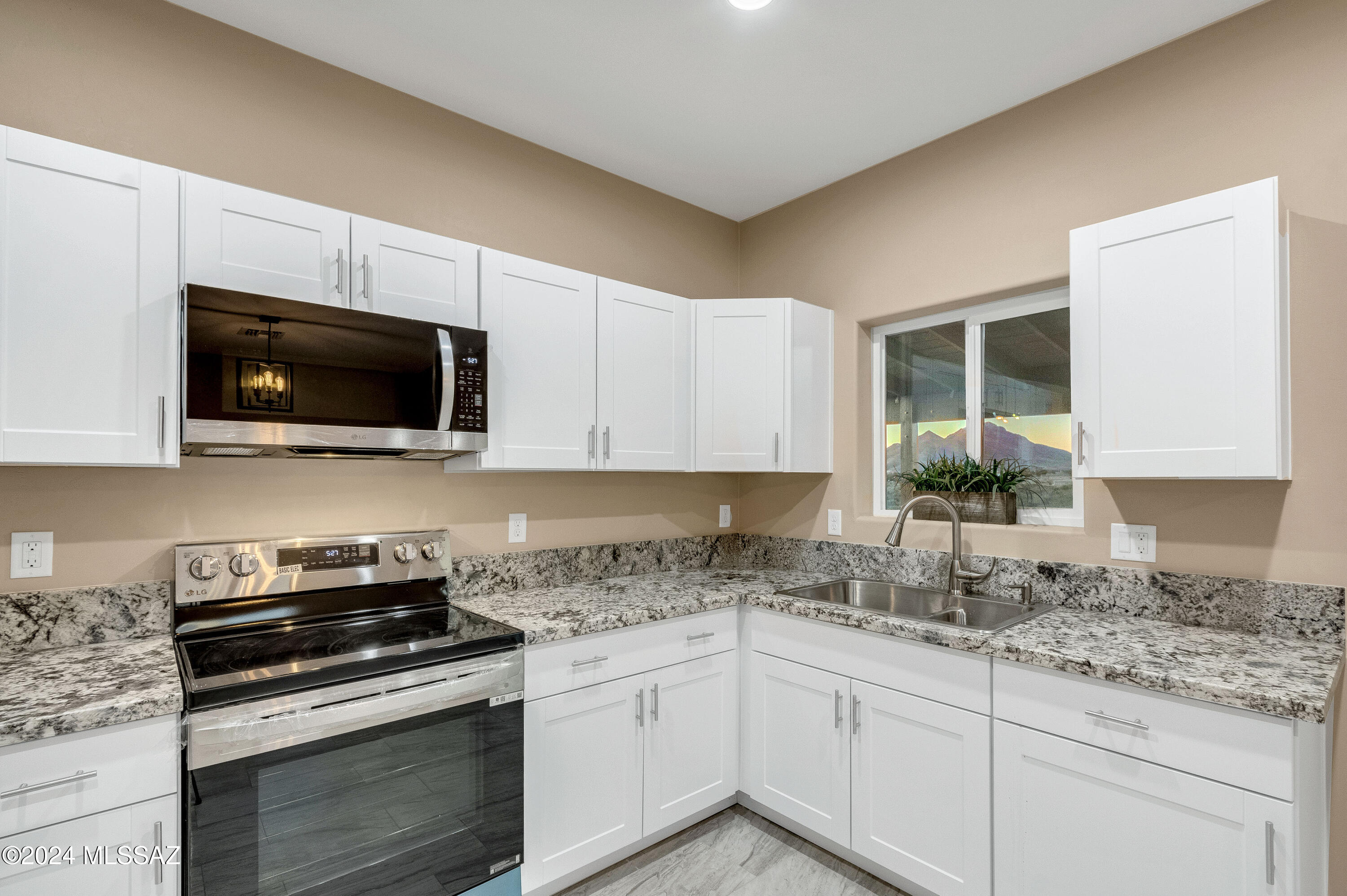 221 Paseo Mascota Rio Rico, AZ 85648 - Photo 15 of 45 a kitchen with granite countertop a sink and a stove top oven
