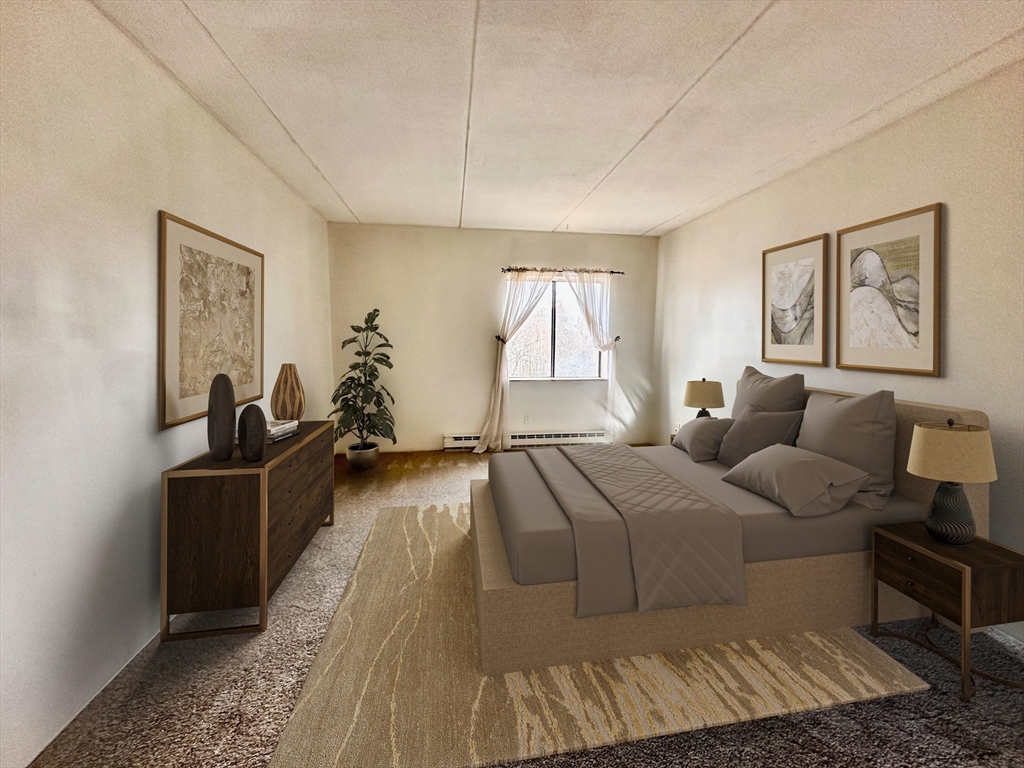 46 Cochituate Road, Unit 408 Framingham, MA 01701 - Photo 13 of 20 a bedroom with a bed and wooden floor