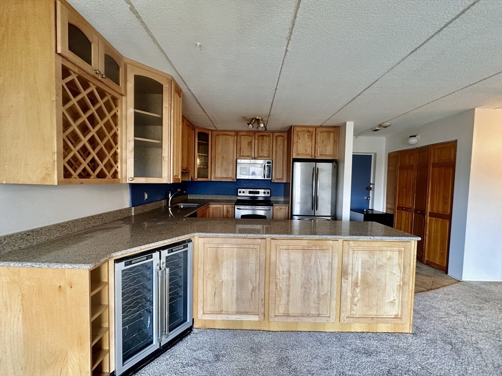 46 Cochituate Road, Unit 408 Framingham, MA 01701 - Photo 6 of 20 a kitchen with stainless steel appliances granite countertop a stove a sink and a microwave