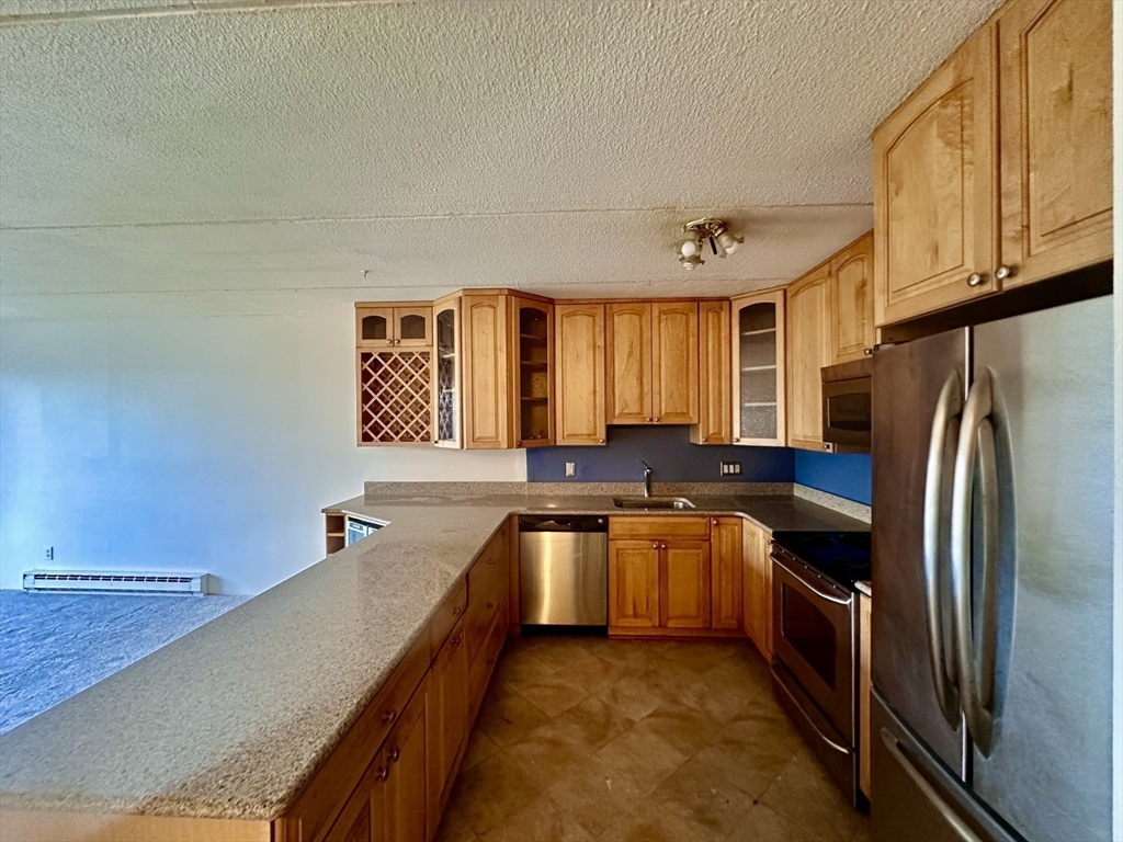 46 Cochituate Road, Unit 408 Framingham, MA 01701 - Photo 7 of 20 a kitchen with stainless steel appliances granite countertop a sink stove and refrigerator