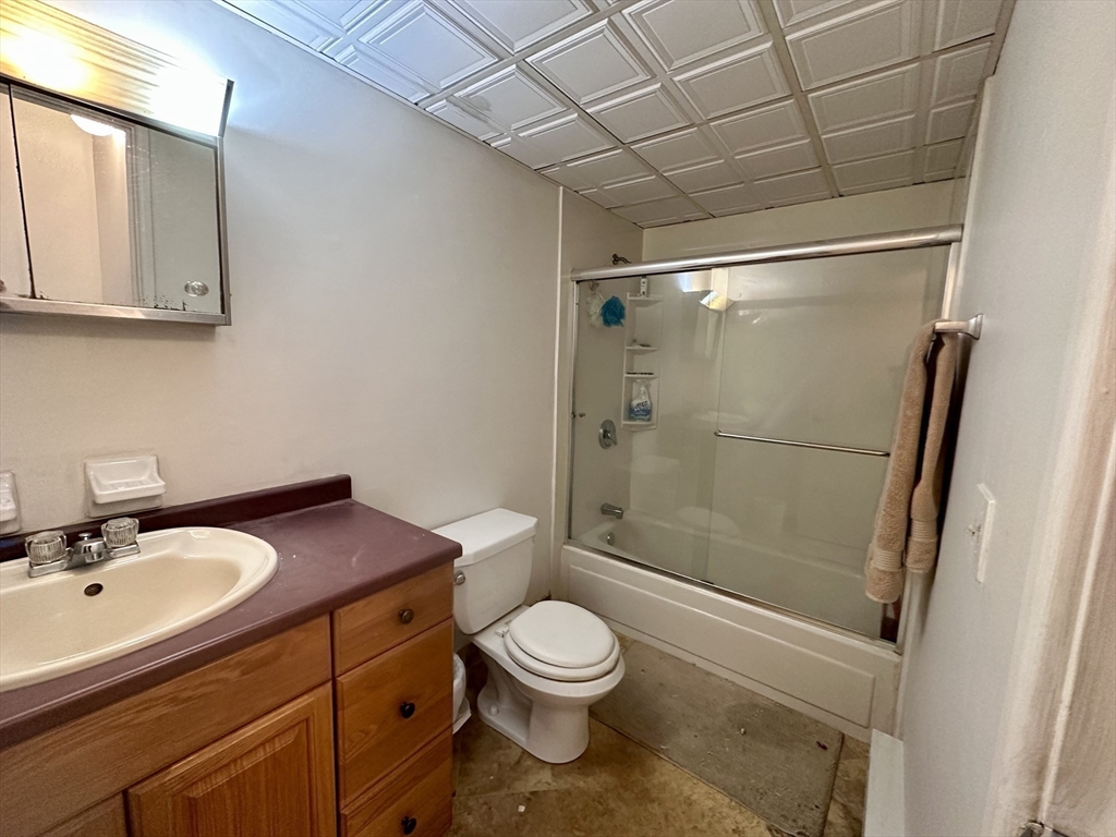 46 Cochituate Road, Unit 408 Framingham, MA 01701 - Photo 10 of 20 a bathroom with a granite countertop sink toilet a mirror and shower