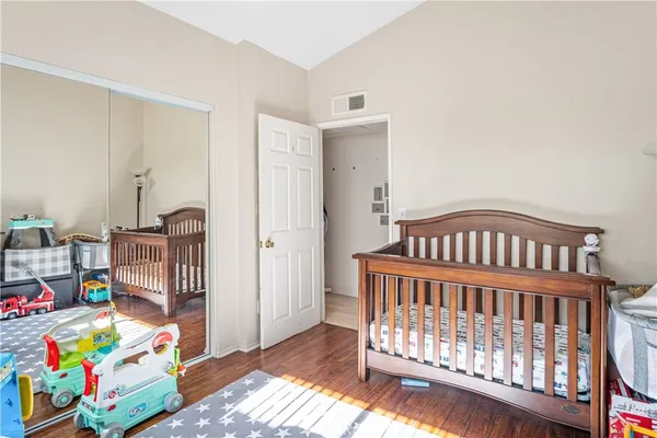 a bedroom with baby crib and wooden floor