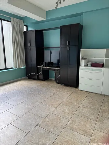 a view of an empty room with closet and a window