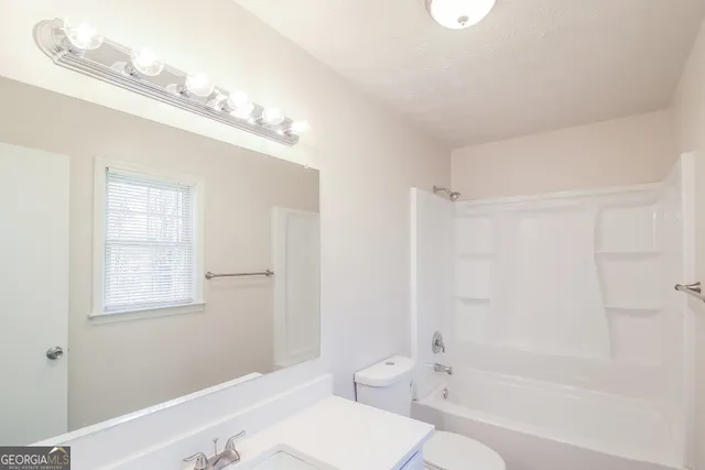 a bathroom with a toilet a sink and bathtub