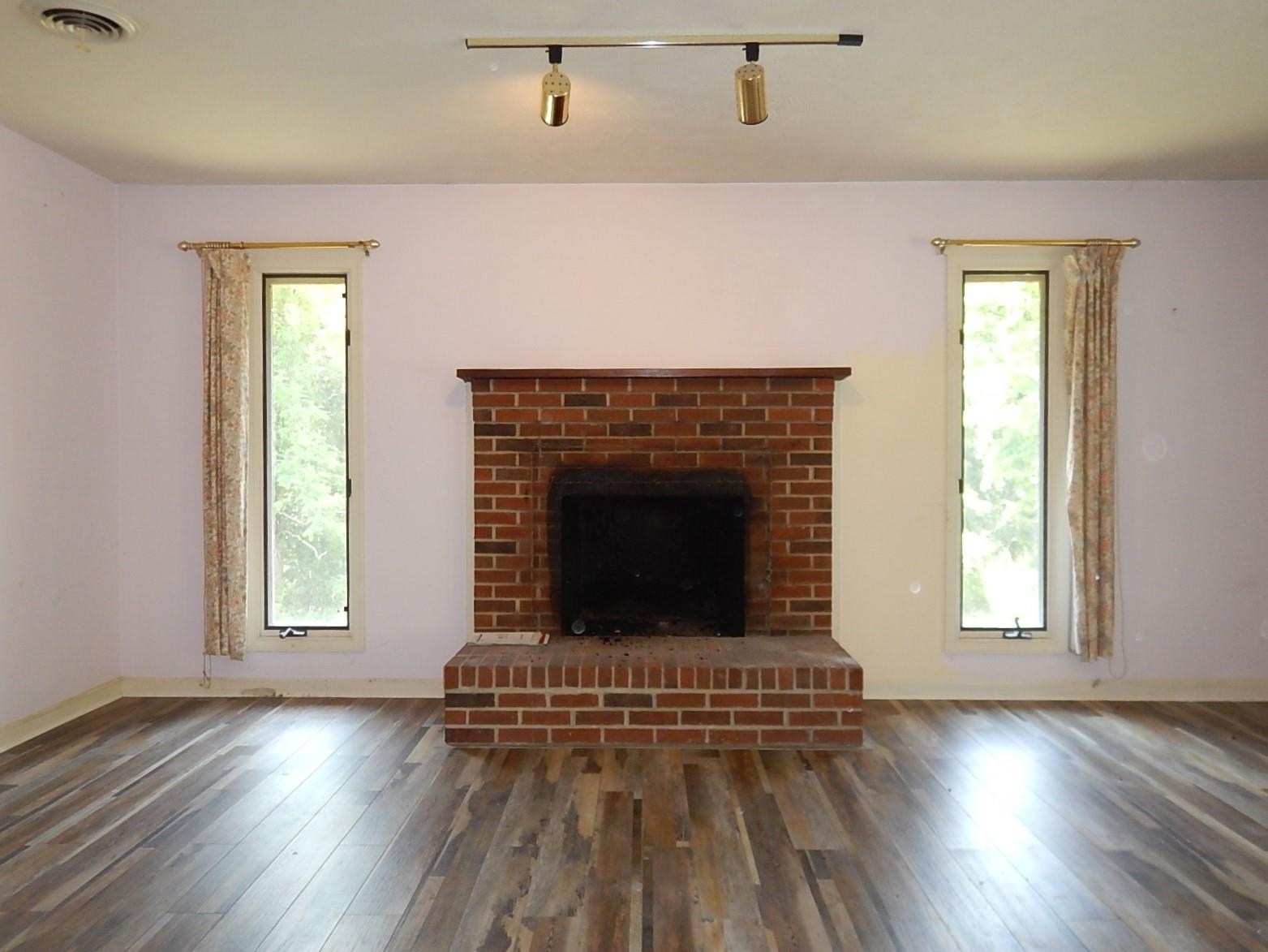 161 Smoky Row Road Staunton, VA 24401 - Photo 11 of 25 an empty room with wooden floor a fireplace and windows