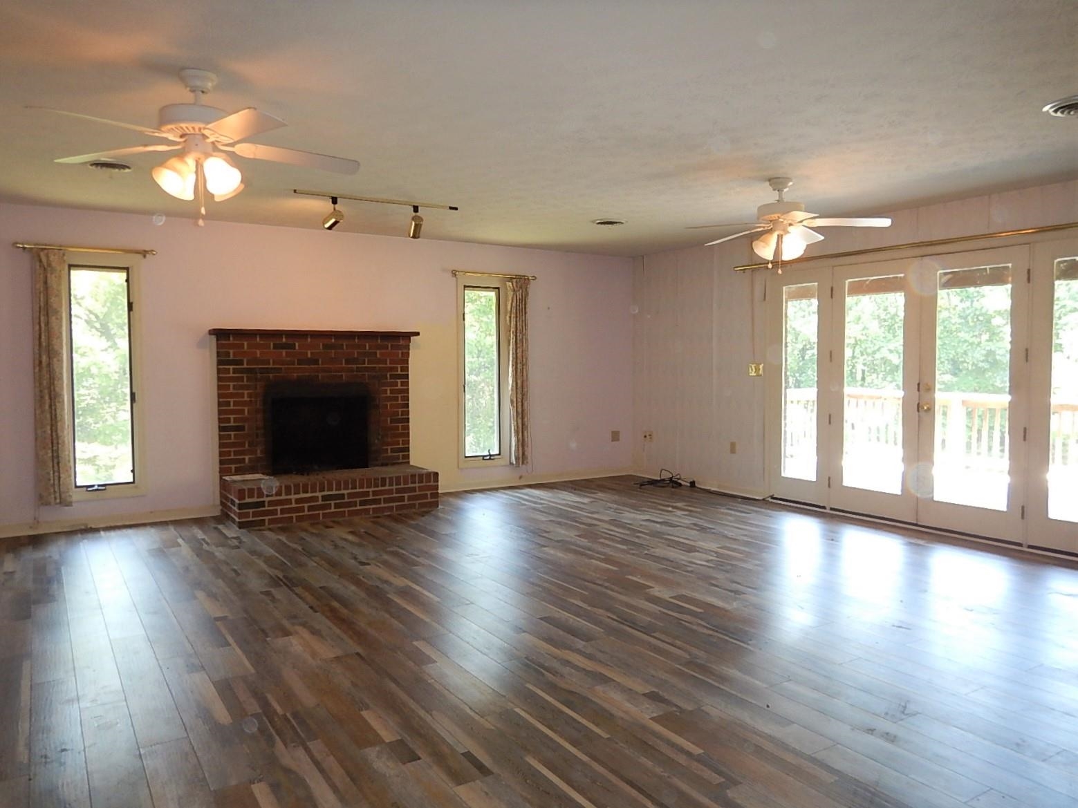 161 Smoky Row Road Staunton, VA 24401 - Photo 10 of 25 an empty room with wooden floor fireplace chandelier and windows