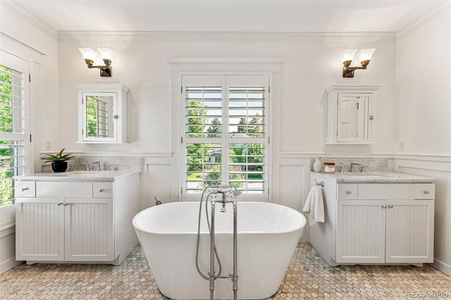 a spacious bathroom with a tub sink and mirror