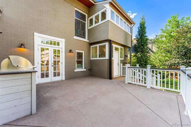 a backyard of a house with plants and large tree