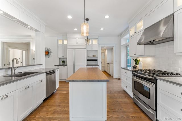 a large kitchen with stainless steel appliances granite countertop a stove a sink and a refrigerator