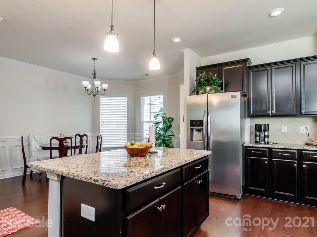 4142 Perth Road Indian Land, SC 29707 - Photo 11 of 26 a kitchen with granite countertop kitchen island stainless steel appliances a sink stove and refrigerator
